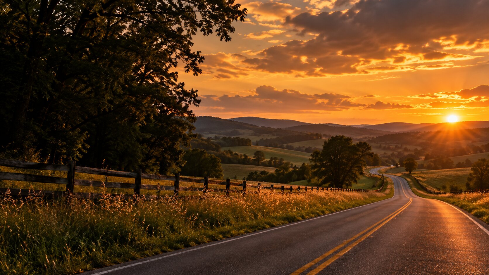A country road at sunset winding through rolling hills